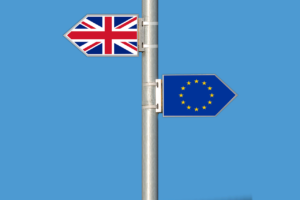 A sign post with a union jack flag pointing one way and the EU pointing the other