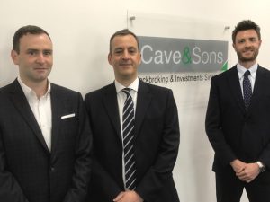 Business men standing by Cave and Sons sign