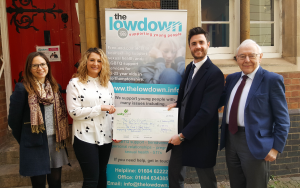 A picture of Ed Caswell from Cave & Sons presenting the £1,000 cheque to Northamptonshire charity, The Lowdown