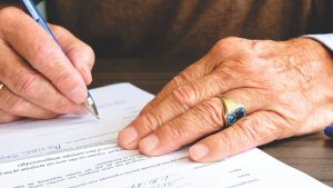 Image of a person signing a legal agreement for their estate after planning their finances for inheritance tax.