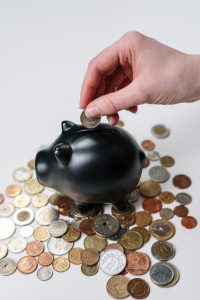 An image of coins beside a piggy bank.